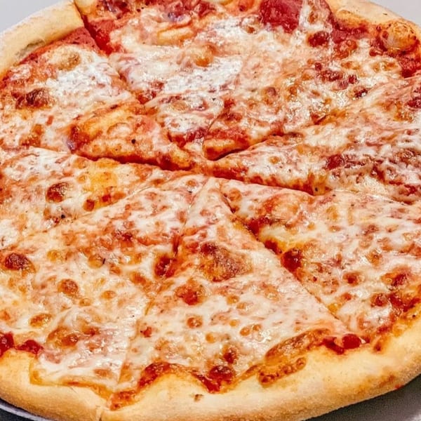 A freshly baked, sliced cheese pizza from Fig & Tomato, with melted mozzarella and red sauce.