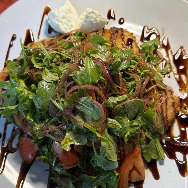 Crispy chicken cutlet topped with arugula, red onion, tomatoes, and balsamic glaze.