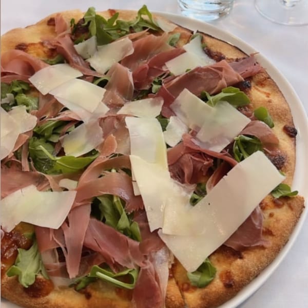 Fig & Tomato's Italian pizza topped with prosciutto, arugula, and shaved Parmesan cheese.